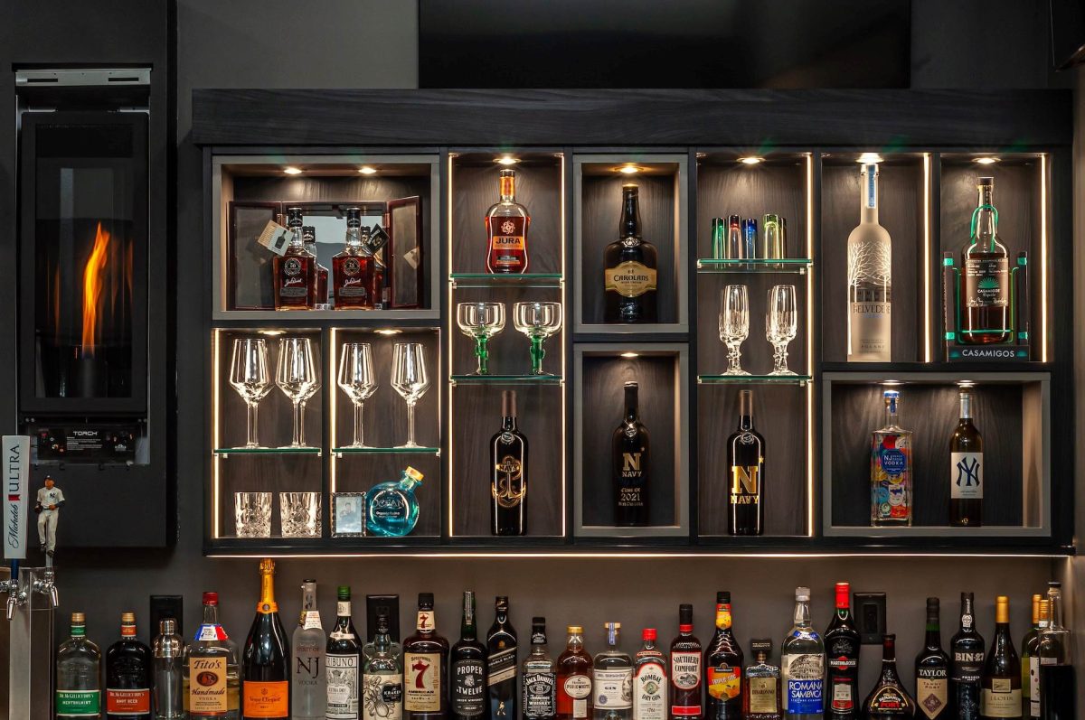 Close-up of an LED-lit home bar with timber grain laminate, showcasing elegant alcohol display