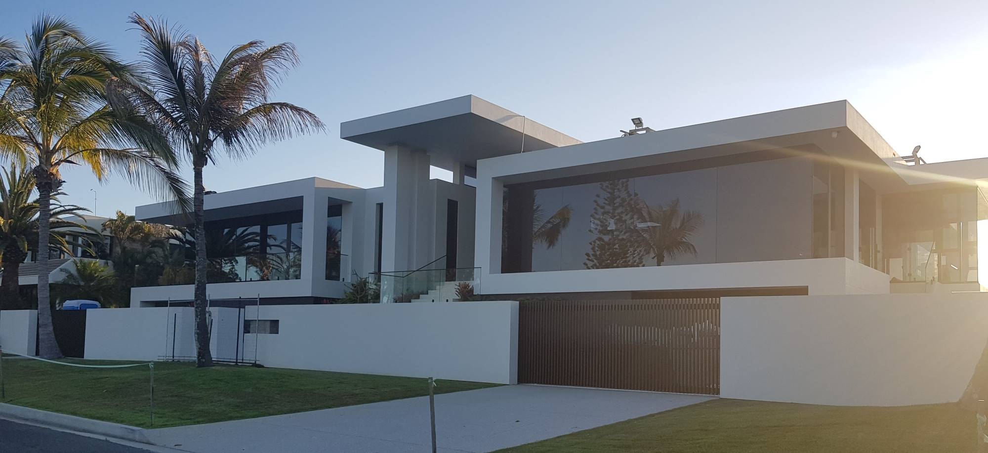 Facade of a luxury custom home in Runaway Bay with grand entry and palm trees
