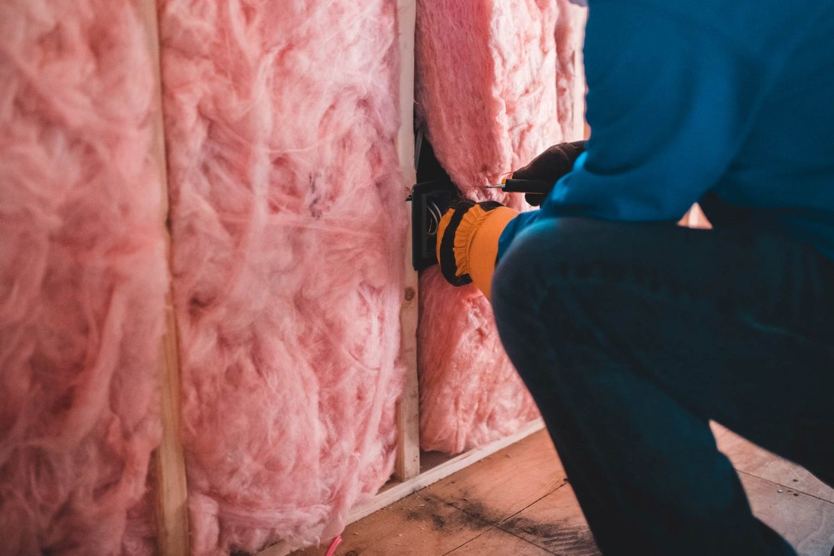 Tradesman installing R2.0 soundproof insulation batts in a home under construction.