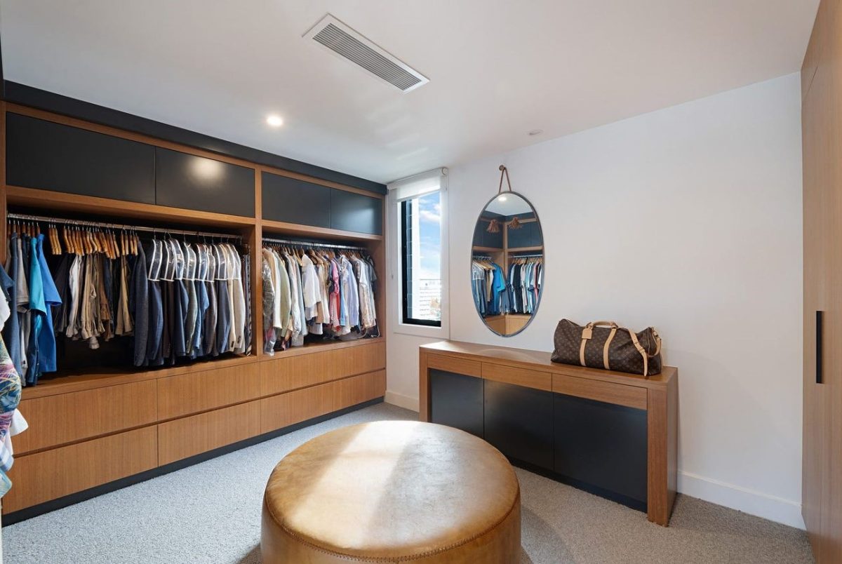 Walk-In Robe at 28 Kookaburra Court, Sorrento, featuring timber laminate built-in cabinetry and a leather circular seat