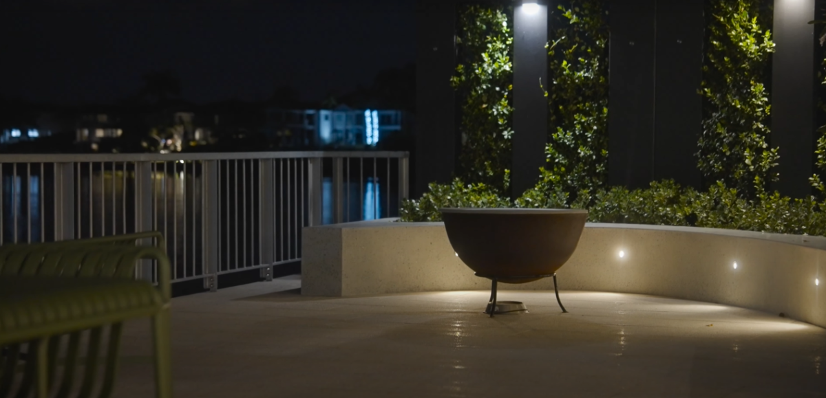 Firepit and curved concrete seating at 28 Kookaburra Court, Sorrento, on the rear terrace at night, with a garden bed behind the seating