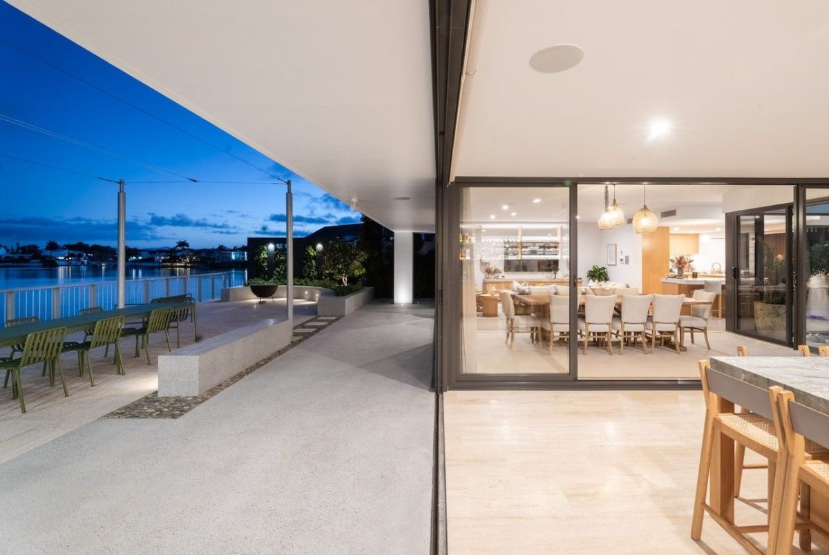 Indoor-outdoor view at 28 Kookaburra Court, Sorrento, showing the entertainment room, dining area, living room, kitchen, and terrace with canal views
