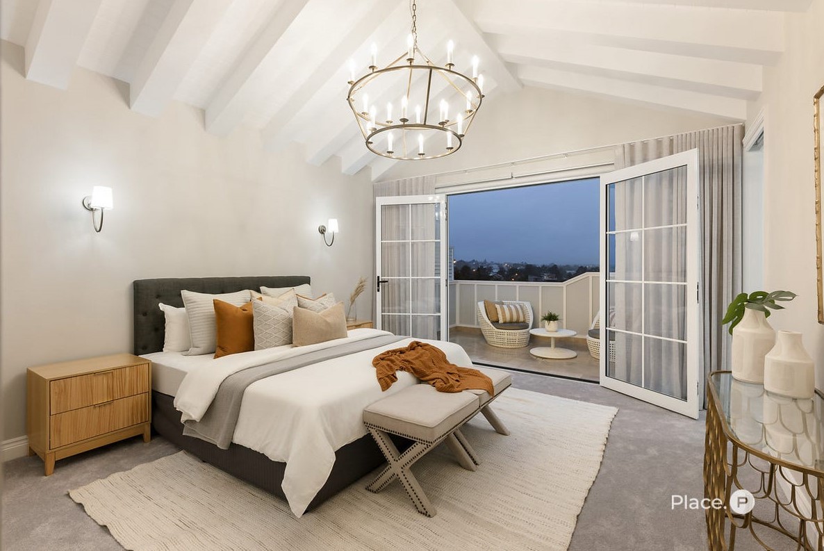 Master bedroom at 63 Oateson Skyline Drive, Seven Hills, featuring a pitched rafter ceiling, smooth plaster finish, and a private balcony with sweeping views.