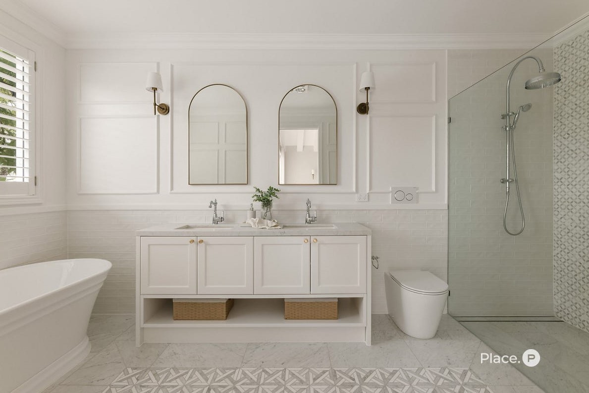 Luxurious master ensuite at 63 Oateson Skyline Drive, Seven Hills, featuring a freestanding bath, vanity with dual undermount basins, frameless glass shower, concealed toilet cistern, and feature floor tiles.