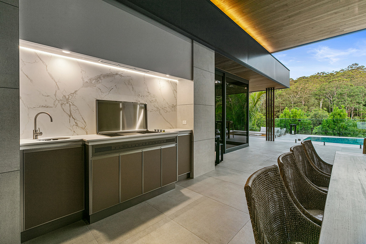 Built-in BBQ area with stone splashback and rangehood in the alfresco at 74 Anning Road, Forest Glen.