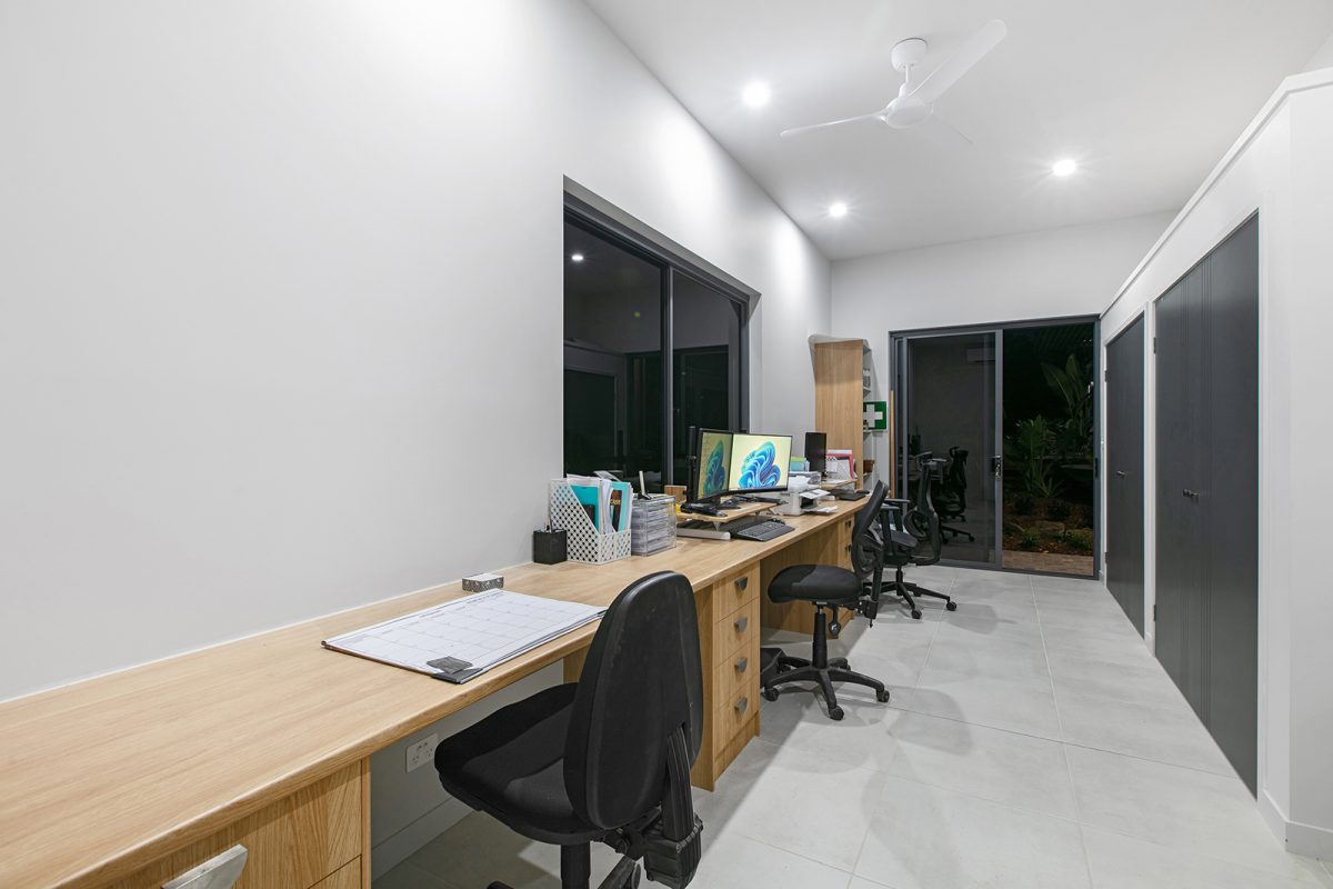 Large home office at 74 Anning Road, Forest Glen with timber desk, storage area, and sliding door to backyard