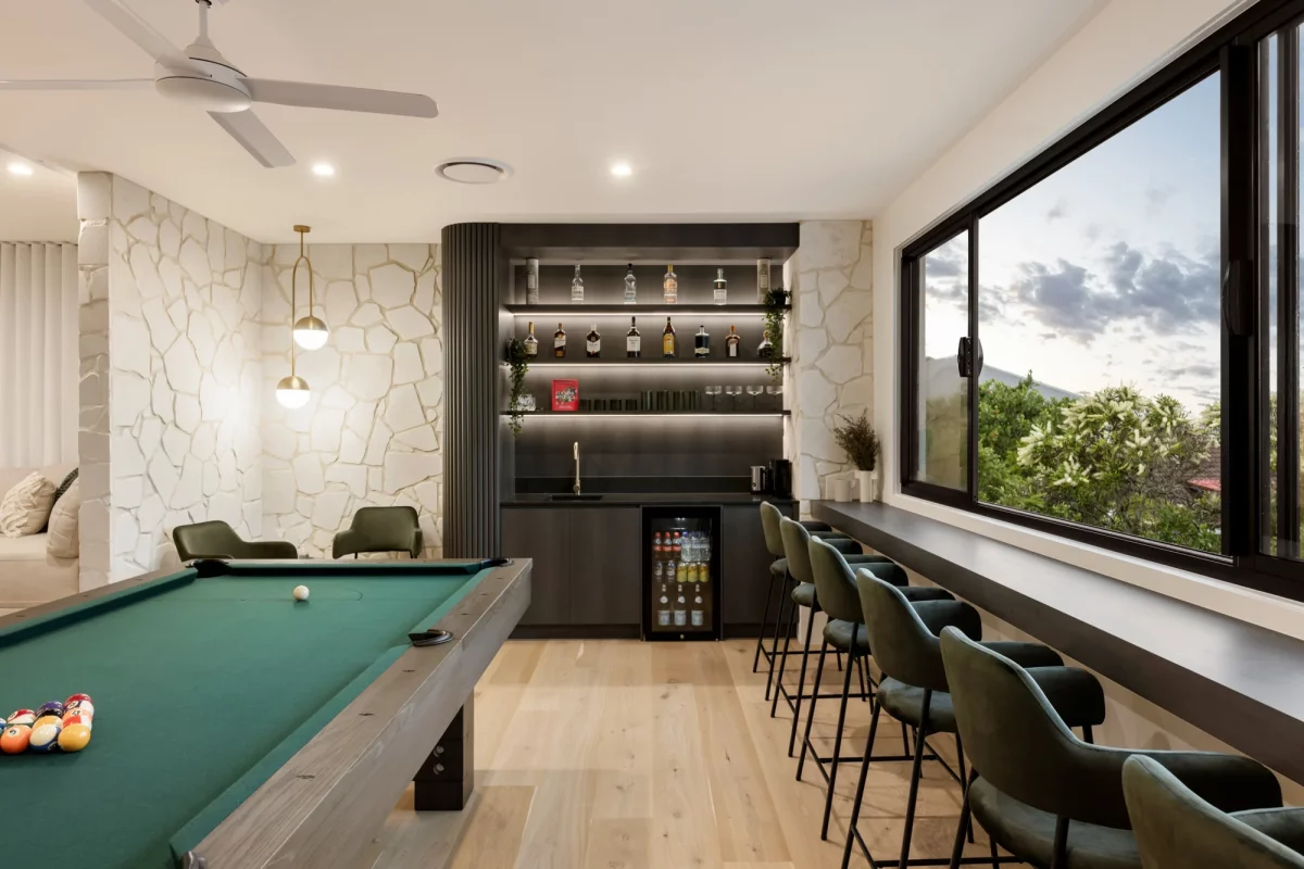 Luxurious first floor entertaining room with bar, pool table, and stack stone feature wall