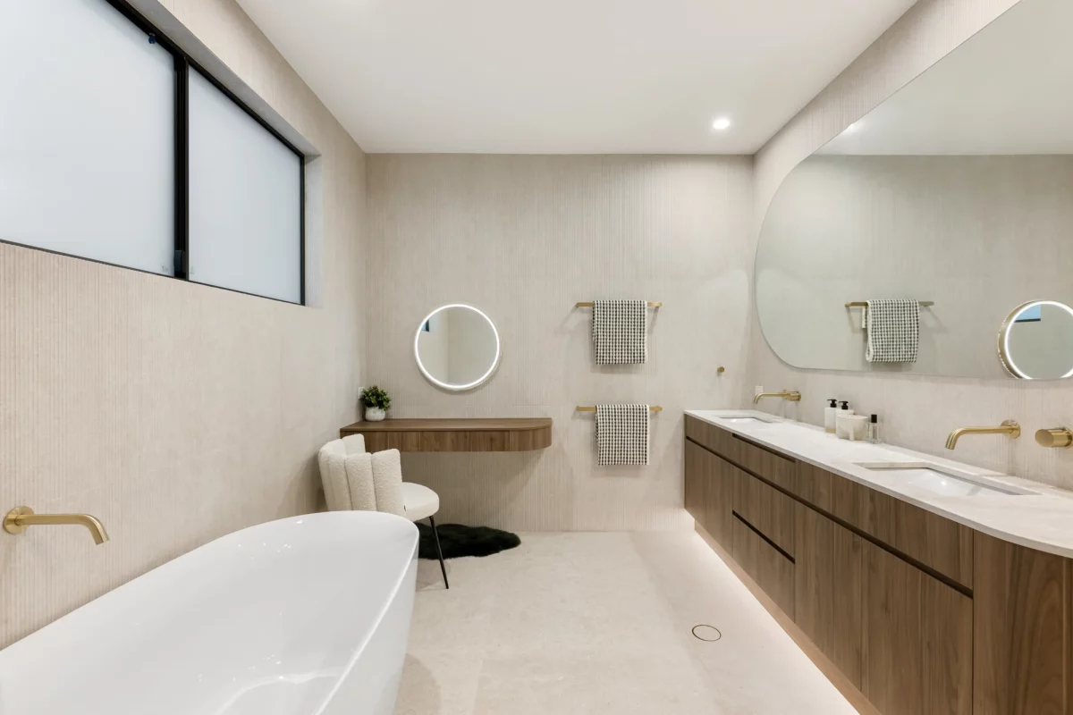 Luxurious master bedroom ensuite with textured wall tiles and freestanding bath