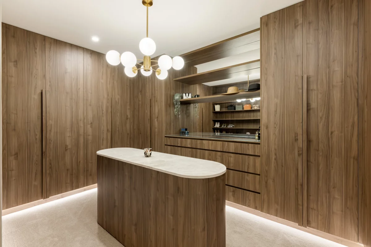 Luxurious walk-in robe with timber grain cabinetry and island bench