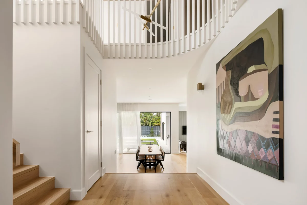 Elegant hallway with timber staircase and views of the dining area